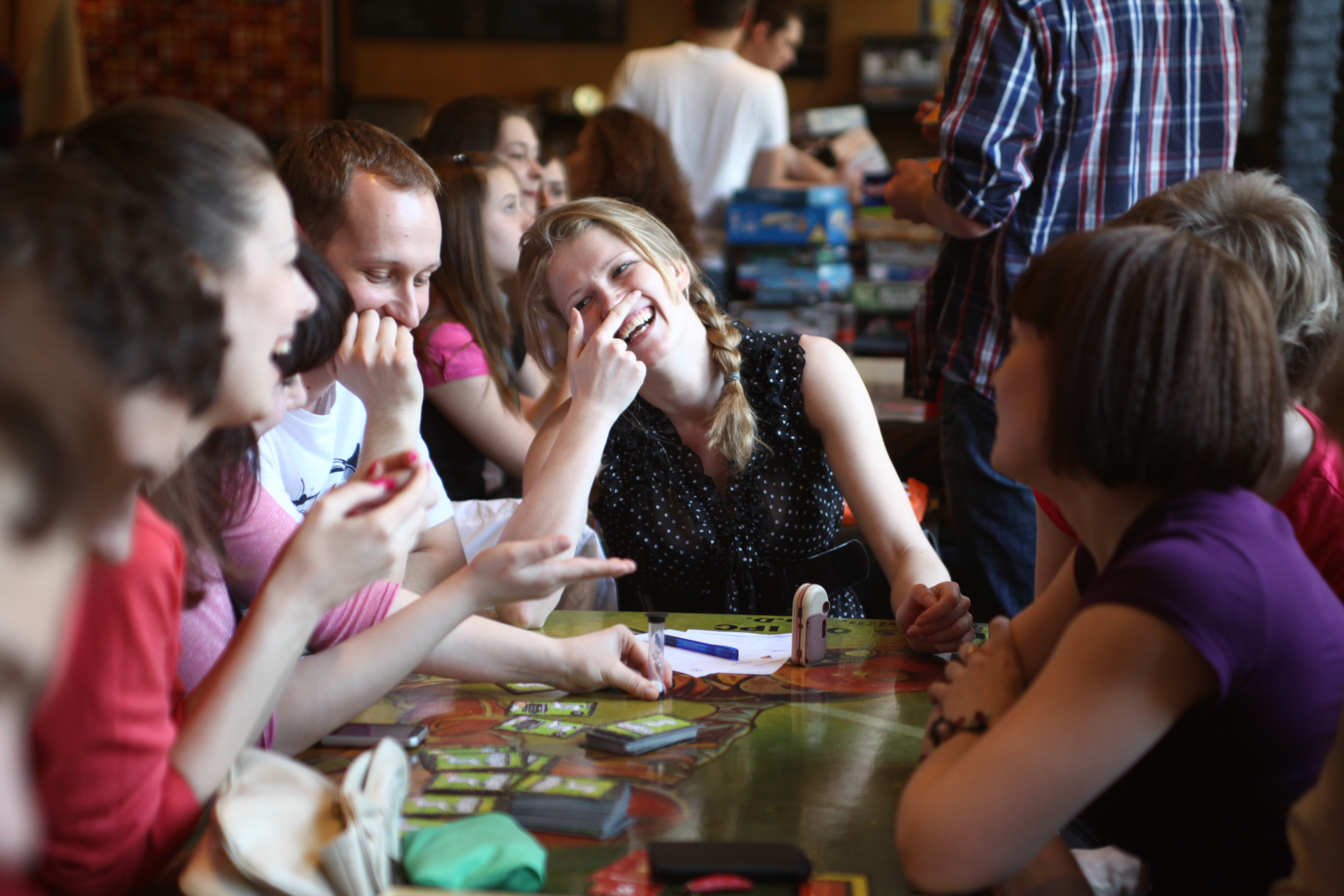 Люди играющие за столом. Подростки за столом. Веселая компания за столом. Люди играют в настольные игры.