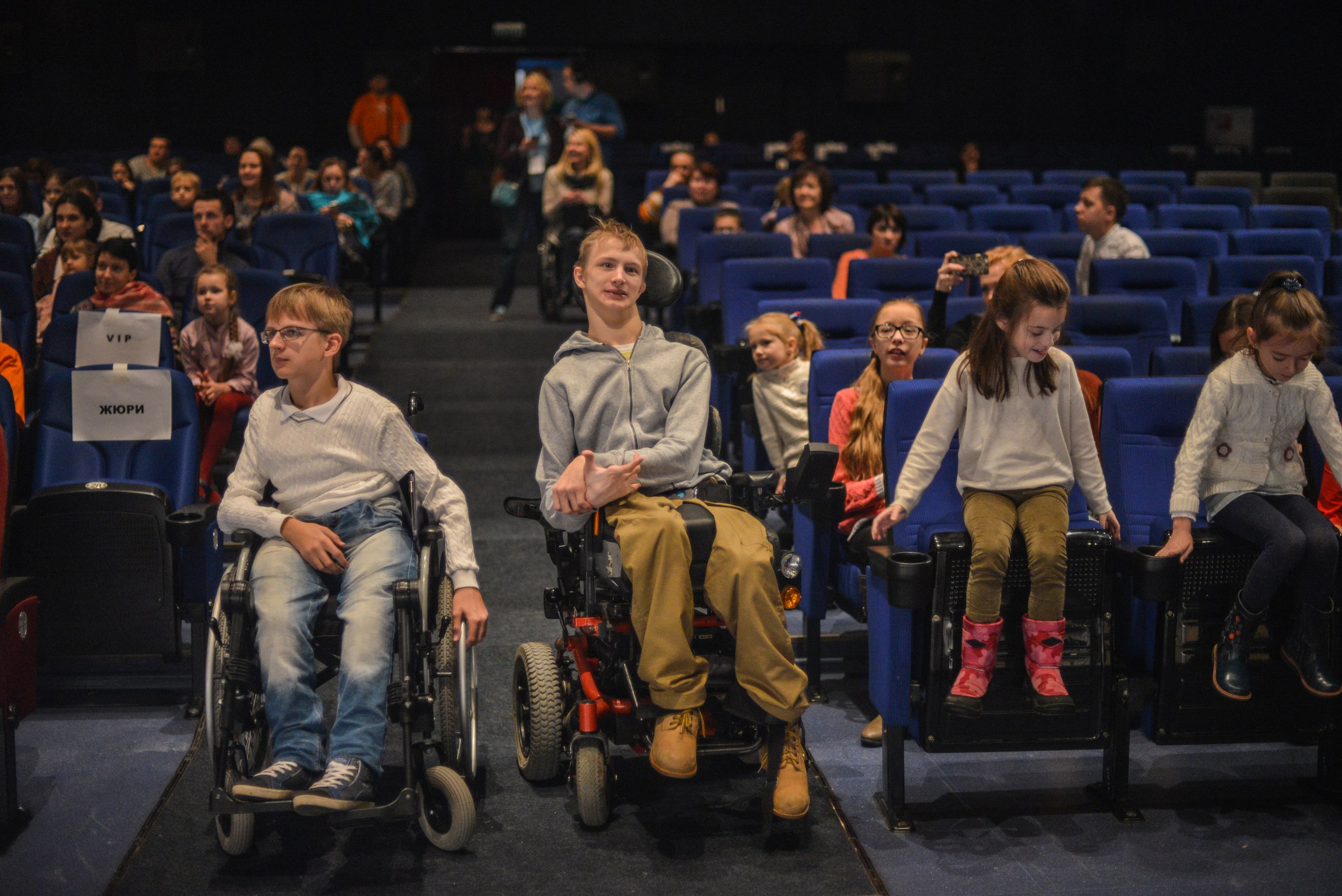 Дети в зрительном зале. Инвалиды в кинотеатре. Театр инвалидов. Театр с детьми инвалидами. Кинотеатр для инвалидов колясочников.